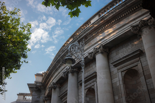 Neo-classical building facade with ornate columns and decorative stonework. Historic Dublin institutional architecture with Ionic capitals.