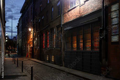 Cuadro en lienzo Atmospheric cobblestone laneway in Dublin with Victorian brick buildings and warm street lighting