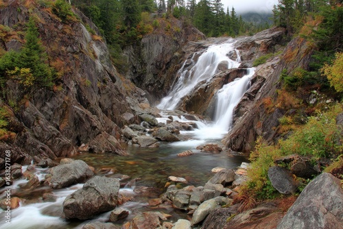 Waterfall cascading down rocky gorge in autumn