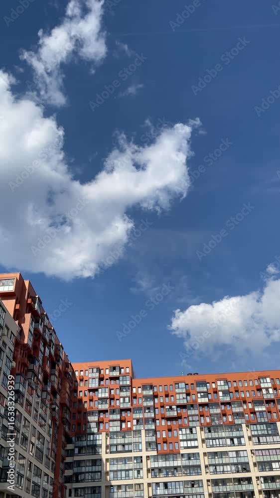 Modern residential building with orange facade and glass windows under ...