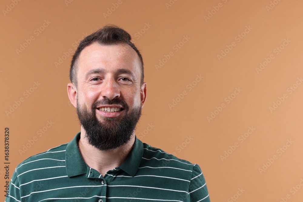 Obraz premium Handsome man laughing on brown background. Space for text