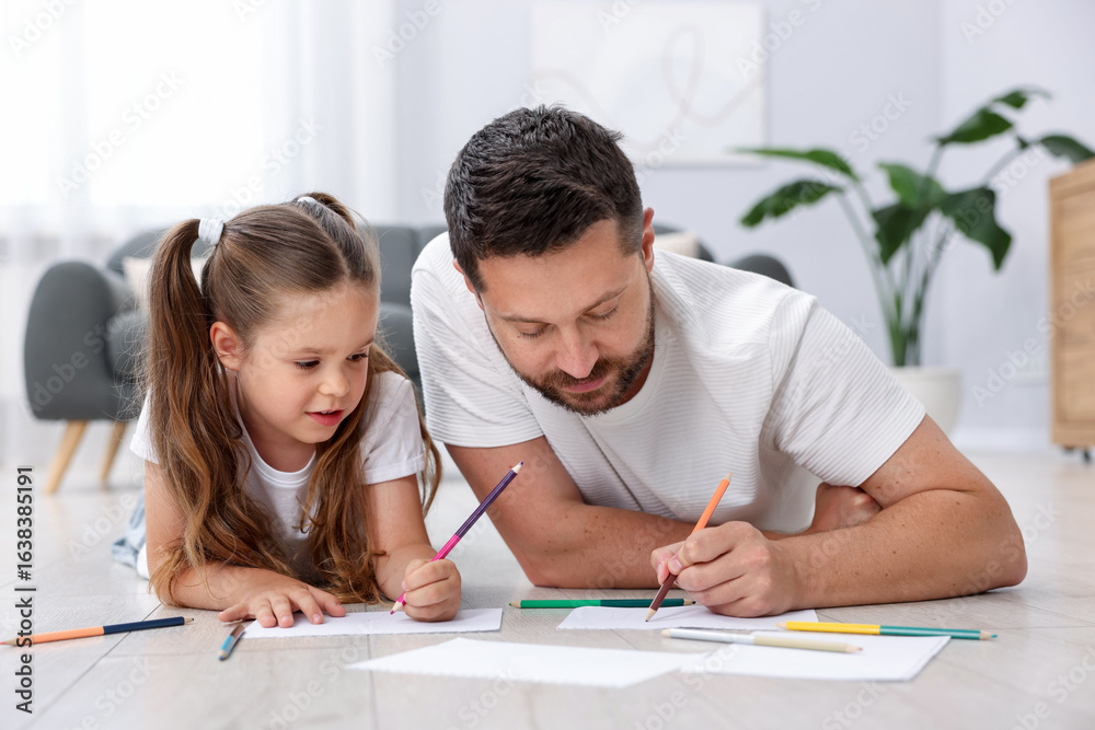 Father and his daughter drawing together on warm floor at home. Heating system Father and his daughter drawing together on warm floor at home. Heating system