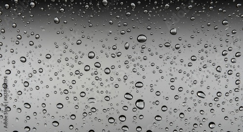 Close-up of water droplets on a dark gray surface
