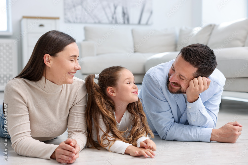 Parents and their daughter together on warm floor at home. Heating system Parents and their daughter together on warm floor at home. Heating system