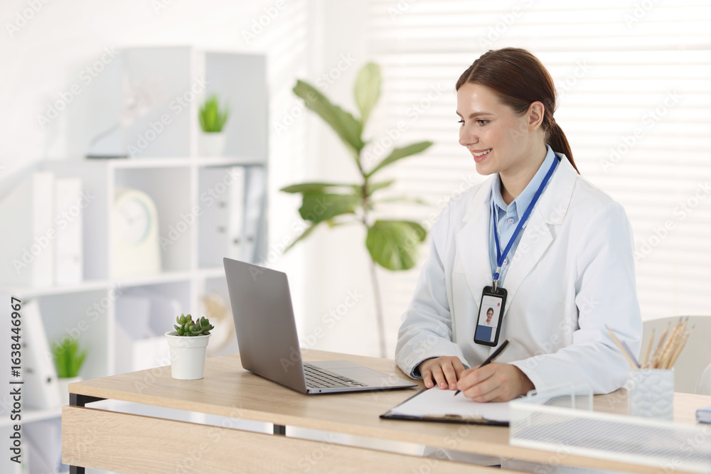 Telemedicine. Doctor making notes while having video call with patient via laptop indoors Telemedicine. Doctor making notes while having video call with patient via laptop indoors