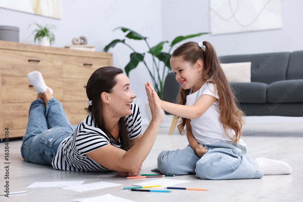 Mother and her daughter drawing together on warm floor at home. Heating system Mother and her daughter drawing together on warm floor at home. Heating system