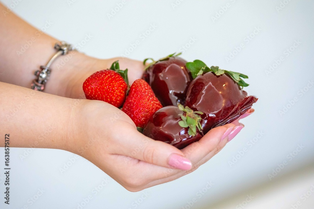 Obraz premium The most perfect sweet in the world, the iconic dessert strawberry of love on a stick, fresh strawberry, powdered milk brigadeiro and red caramel topping. Morango do amor