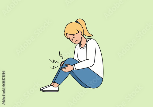 Young woman sitting on the floor, holding her knee in pain, illustrating a knee injury or discomfort, with a light green background