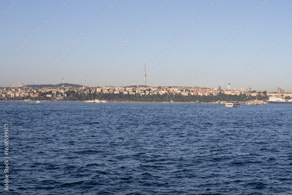Fototapeta premium Scenic Bosphorus Strait in Istanbul at sunset with urban skyline, iconic bridges, fishing boats, and calm sea, highlighting the beauty and cultural heritage of Turkey’s most famous waterway