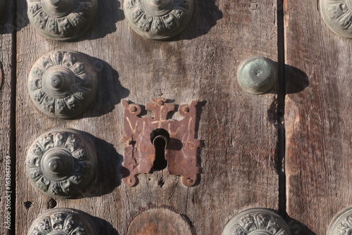 detail of antique door with lock and decorative studs in granada spain