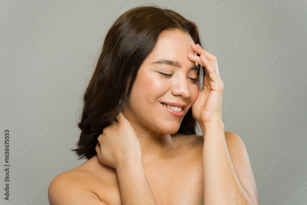Cute woman touching her face and neck, enjoying skincare routine Cute woman touching her face and neck, enjoying skincare routine