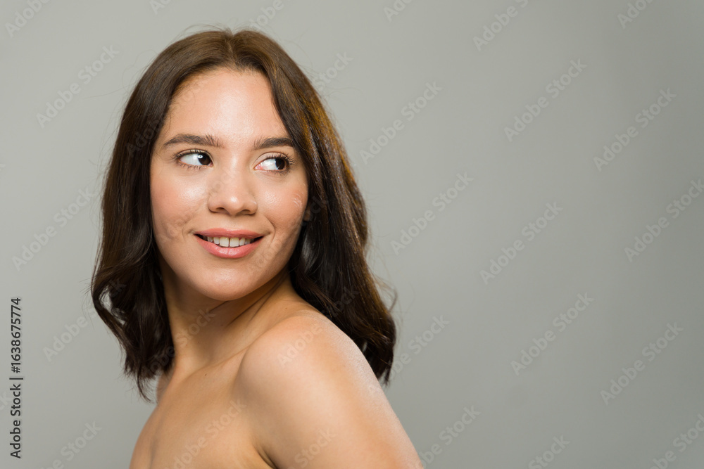 Obraz premium Cute latin woman showing perfect skin and smiling