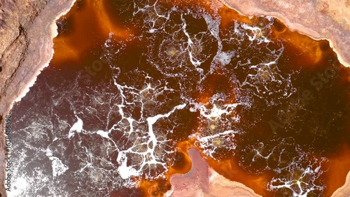 Aerial view of bubbling hot springs in Dallol, Ethiopia, featuring vivid red volcanic terrain
