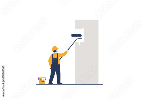 A builder in a yellow hard hat and uniform is painting a tall wall with a roller. A professional construction worker focused on interior decoration and home renovation.