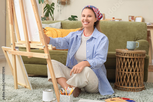 Smiling young woman paintin...