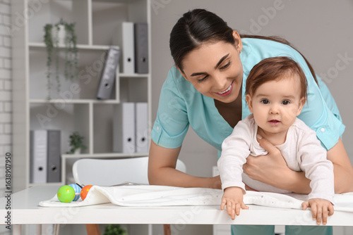 Smiling pediatrician examin...