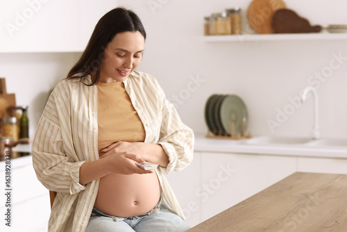 Young pregnant woman using ...