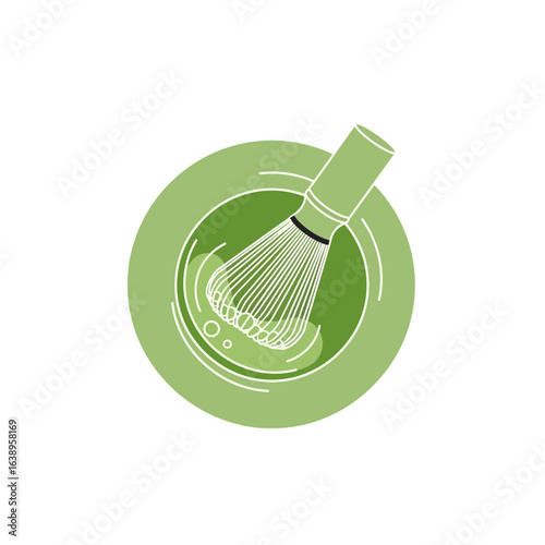 Green whisk in a bowl with foamy liquid.