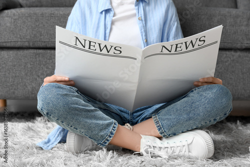 Young woman reading blank n...