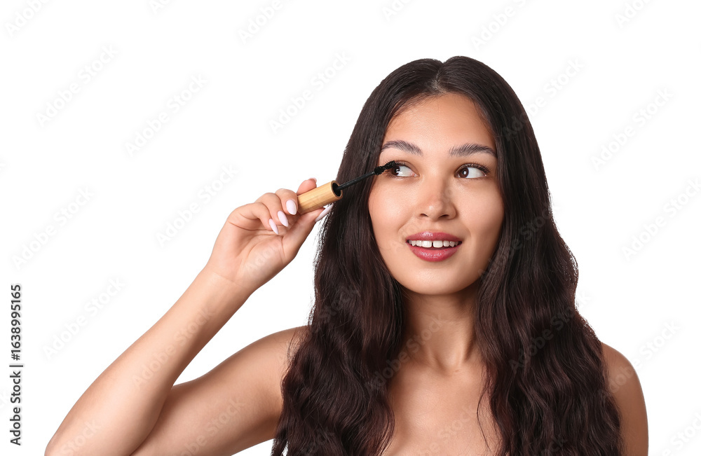 Beautiful young Asian woman applying mascara on white background Beautiful young Asian woman applying mascara on white background