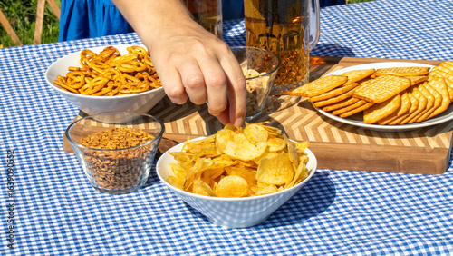 Valokuva Hand reaching for crispy delight at a gingham-laden picnic, reminiscent of Oktob