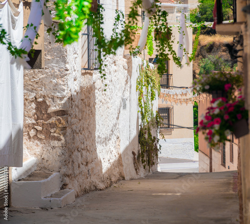 Town street decorated with flowers, in Molinicos village, Castilla la Mancha, Spain.
