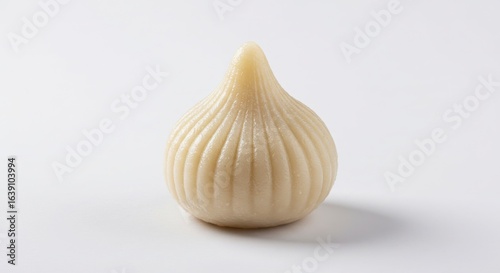 Isolated Indian modak rice flour dumpling with coconut filling on a plain background for culinary or dessert use