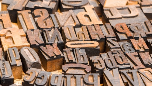 A close up shot of vintage letterpress blocks arranged randomly across a surface in a studio setting