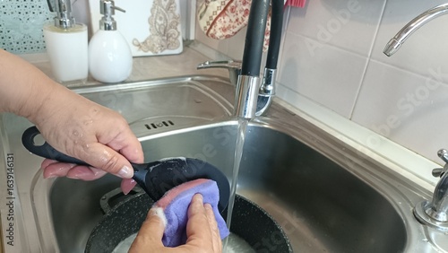 woman washing hands. Hands Washing Dishes.
​Kitchen Chores.. ​Cleaning a Pot.