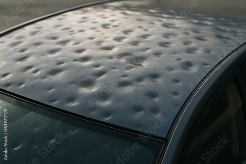 Car roof dented by hailstorm damage