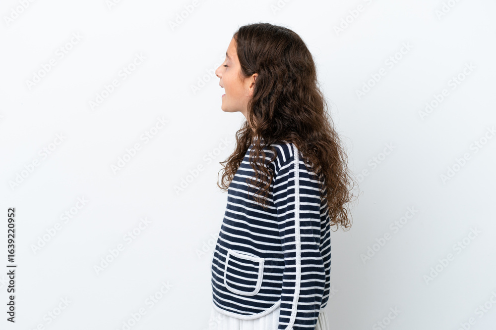Little caucasian girl isolated on white background laughing in lateral position Little caucasian girl isolated on white background laughing in lateral position