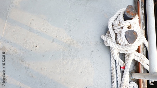 Mooring rope of vessel. Rope tied on ships. Ship’s rope tied on deck for safety. Sailboat rope line at bollards. Mooring bollard with a rope on vessel.
