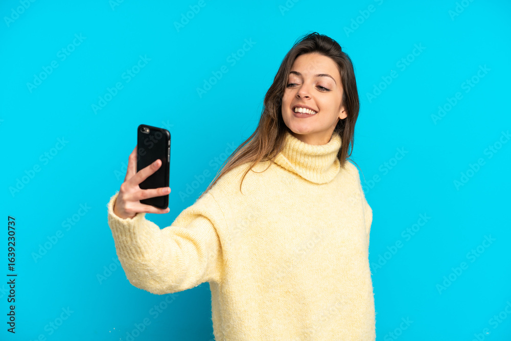 Young caucasian woman isolated on blue background making a selfie Young caucasian woman isolated on blue background making a selfie