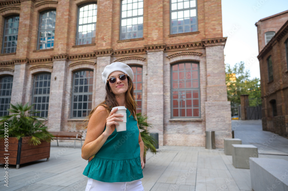 Fototapeta premium Stylish woman enjoying a coffee break in a european city