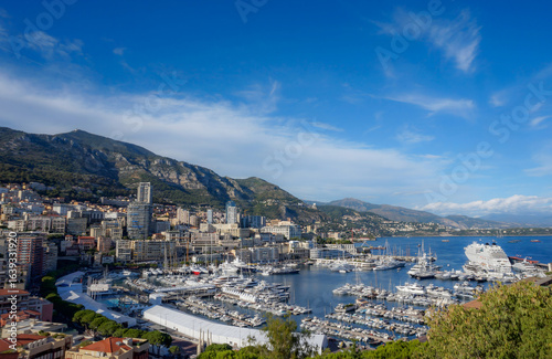 Monaco city skyline and Port Hercules marina under blue sky