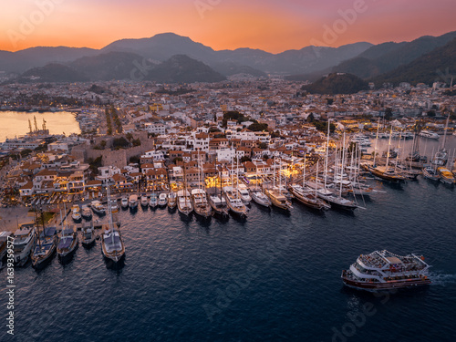 Sunset landscape of coastal town with illuminated street, sailboats and yachts, Marmaris, Türkiye