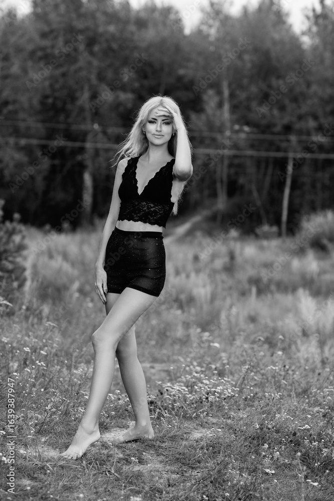 Portrait of a young beautiful blonde girl in light clothes outdoors in summer. Black and white photo. Portrait of a young beautiful blonde girl in light clothes outdoors in summer. Black and white photo.