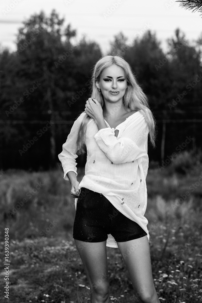 Portrait of a young beautiful blonde girl in light clothes outdoors in summer. Black and white photo. Portrait of a young beautiful blonde girl in light clothes outdoors in summer. Black and white photo.