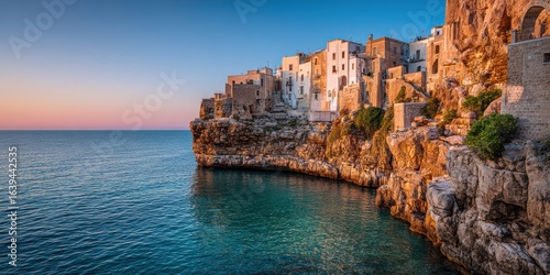 Fototapeta Naklejka Na Ścianę i Meble -  Sunset over cliffs with terraced homes and calm blue sea