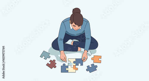 Concentrated woman assembling colorful jigsaw puzzle pieces on the floor