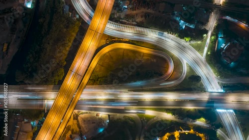 Time lapse of night scene at busy street light trail aerial view. Zoom out
