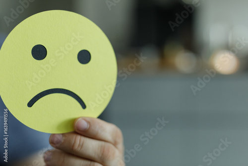 A hand holding a yellow sad...