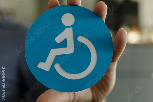 Hand holding a blue circle ...