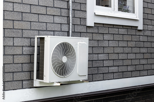 the external unit of the air conditioner is attached to the wall of the house. outdoor air conditioner unit. air conditioning system of a residential building. external air conditioner unit