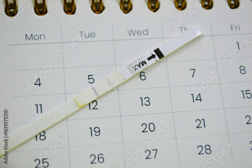 Billede på lærred pregnancy test showing two stripes on white clean calendar