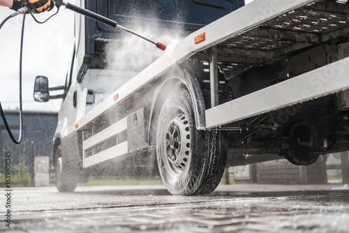 Fotografie Person Washing a Delivery Truck With a Pressure Washer at a Service Station