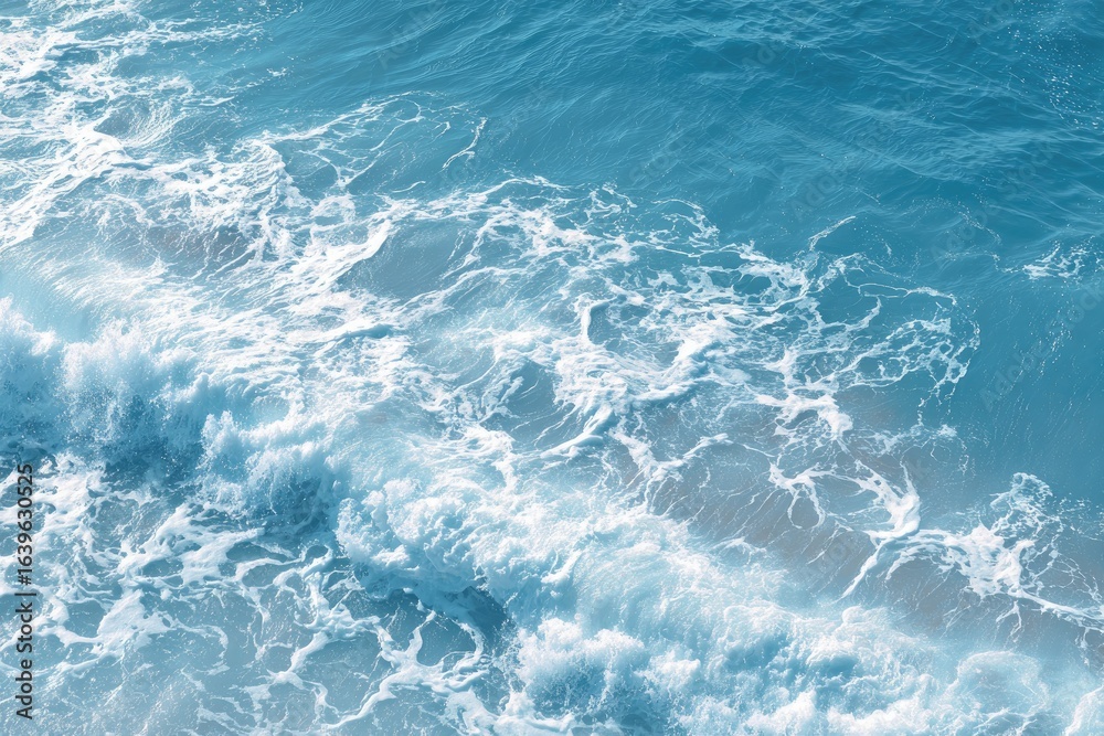 Obraz premium High-angle view of crashing waves. A pattern of foamy white crests on a deep, vibrant blue sea