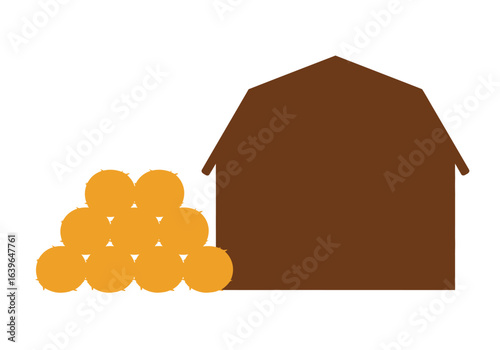Silhouetted brown barn and a stack of golden hay bales