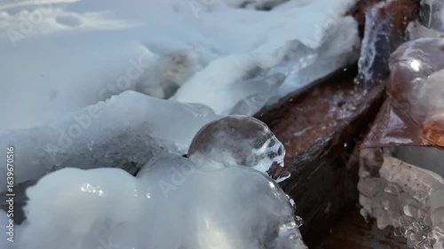 Falling water in a cold stream, frozen ice against the frozen ground