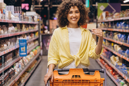 Foto Woman Showing Fidelity Card While Shopping in Supermarket